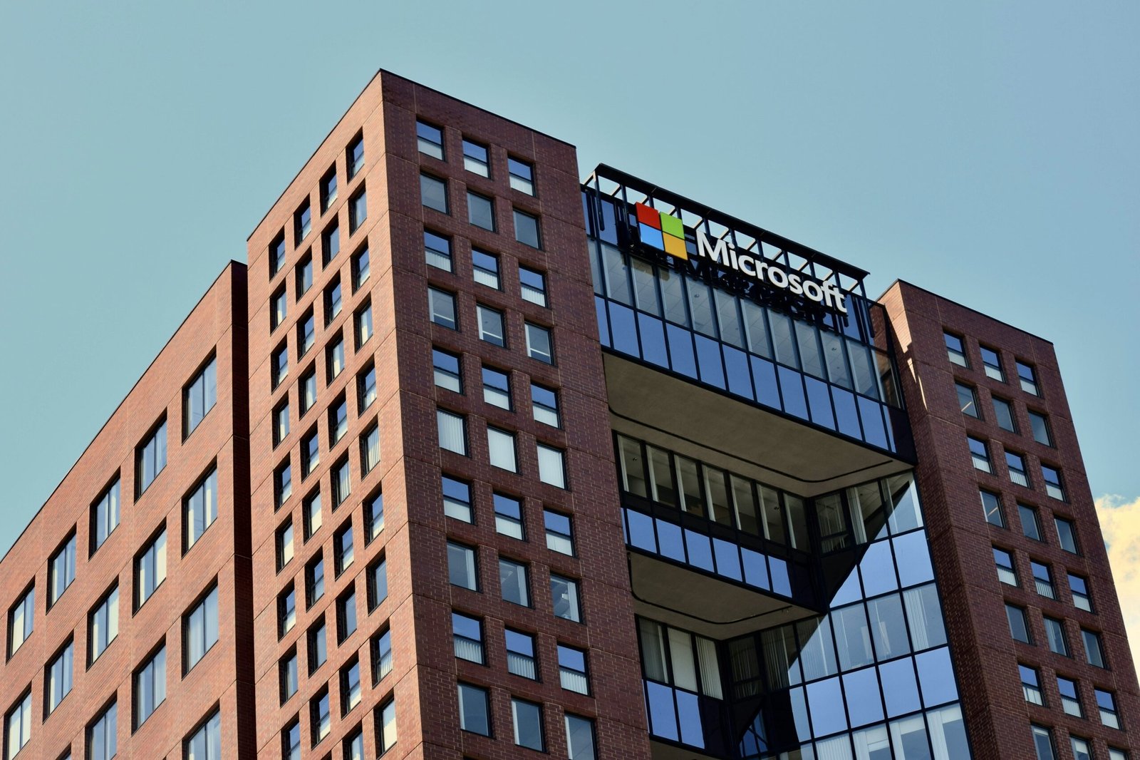 a tall brick building with windows and a sky background